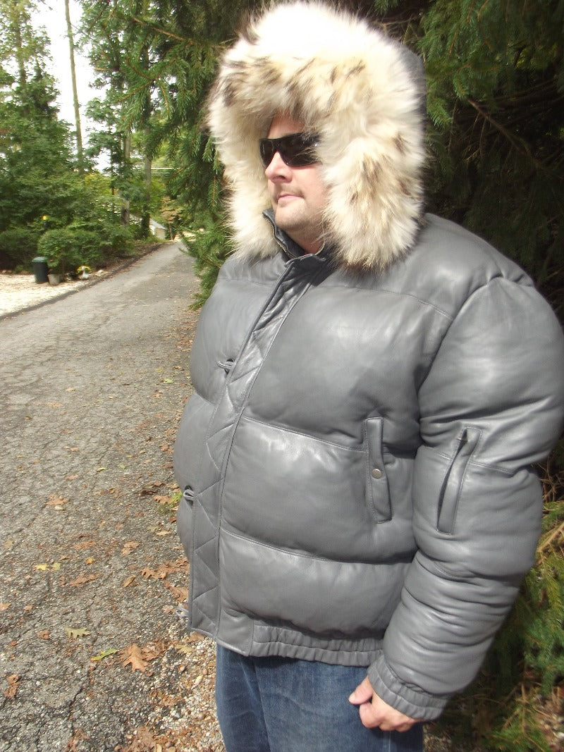 Picture of a model wearing our Max Julian Leather Jacket. Gray Color side view with fur lined hood up.