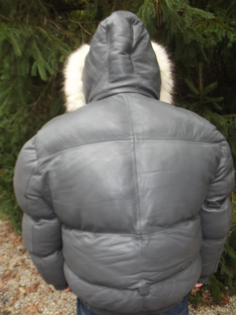 Picture of a model wearing our Max Julian Leather Jacket. Gray Color back view with fur lined hood up.