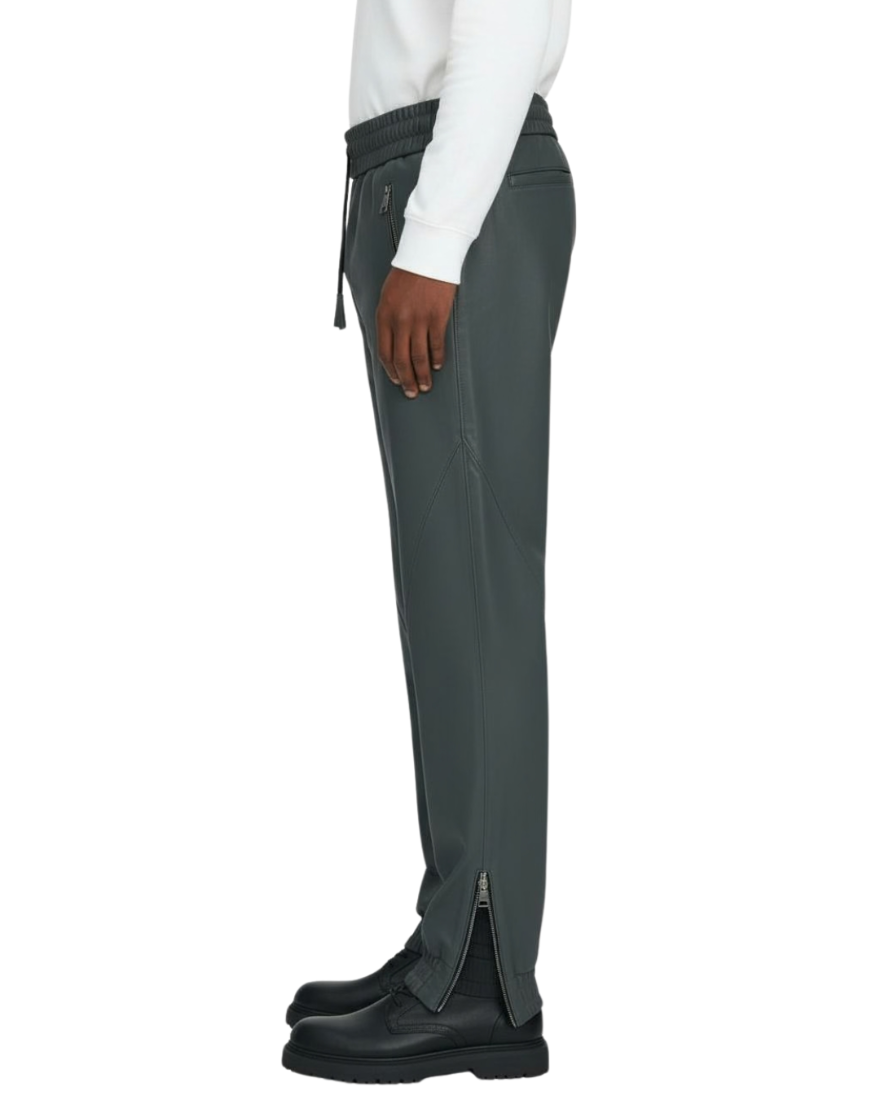 Grey leather joggers worn by a person on a white background