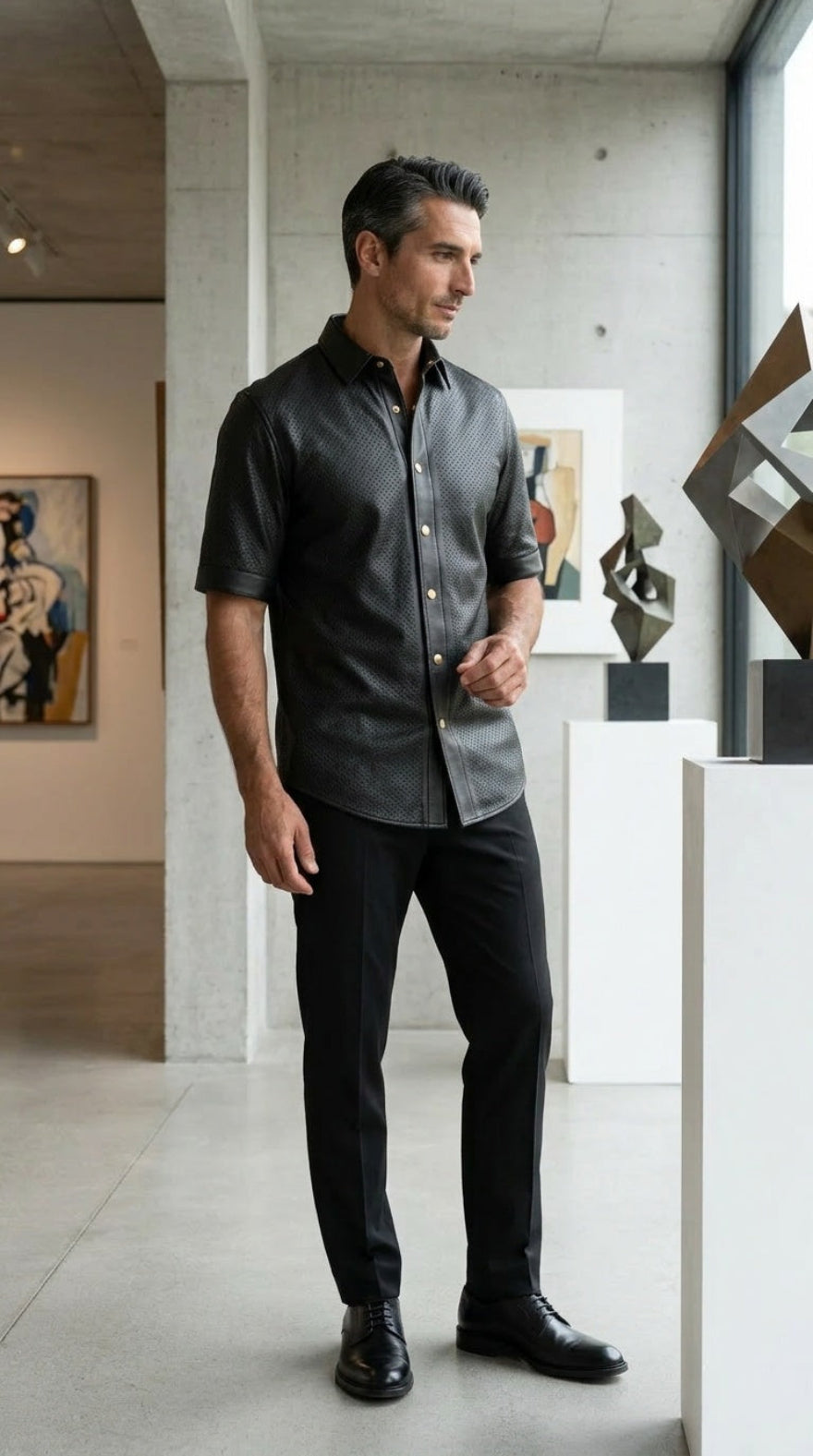 Man in our Mens Black Perforated Leather Shirt | Short Sleeve Nappa Button Up, standing in an art gallery.