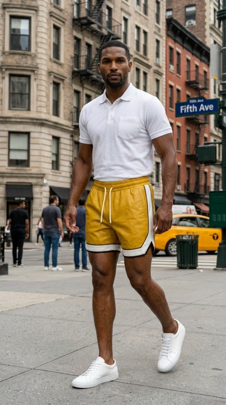 Picture of a man wearing our Yellow Men's Leather Shorts with Contrast Side Stripe and a white polo shirt,  walking on a New York City street.
