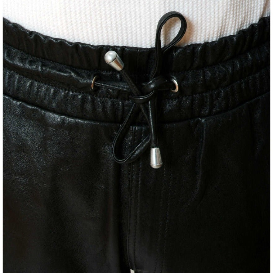 Picture of a model wearing Mens Black Leather Shorts, close up view of the elastic waistband.