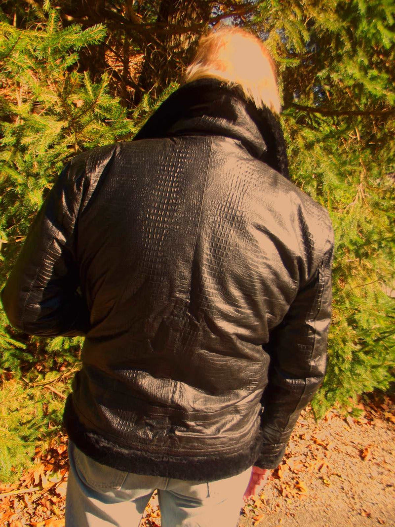 Picture of a model wearing our Black Leather Aviator Jacket, back view with evergreen trees in the background.