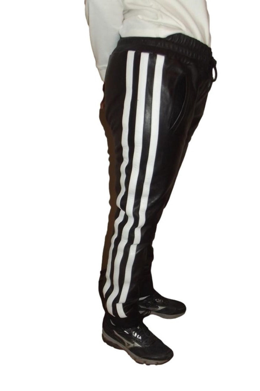 Picture of model wearing our Mens Black Leather Jogging Pants with 3 wide white stripes on outside of leg, side view.