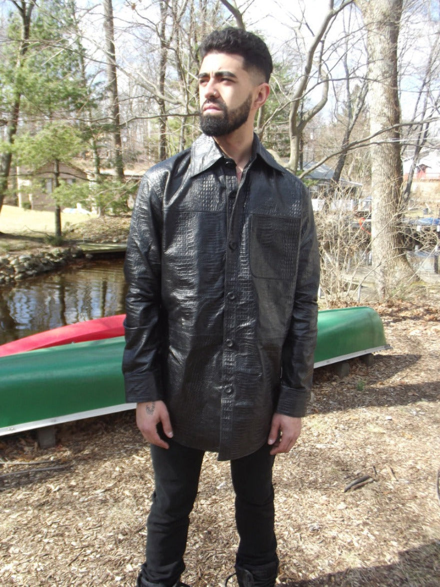  Picture of a model wearing our Mens Black Leather Alligator Shirt , front view in a wooded area and stream in the background.