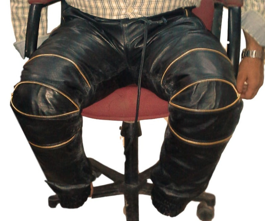 Picture of a model wearing our Black Snakeskin Pants Mens with 3 knee zippers, front view in sitting position.